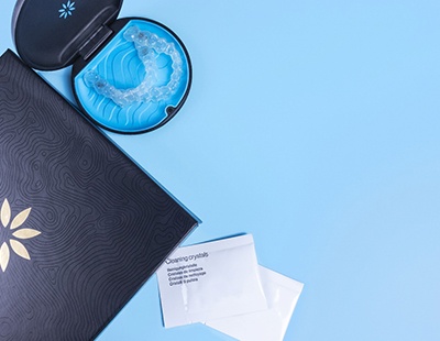 a welcome kit for Invisalign in Aspen Hill containing aligners, cleaning crystals, and a folder