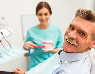 Man smiling with dentist at routine dental appointment