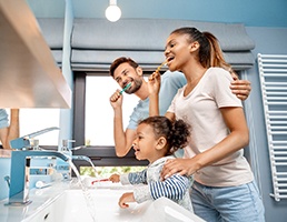 Family brushing teeth with goal of preventing dental emergencies