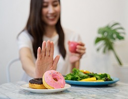 Woman choosing to eat salad instead of unhealthy foods