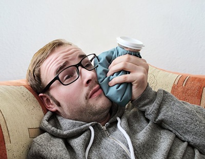 man holding ice pack to his cheek 