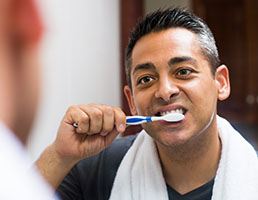 man brushing his teeth 