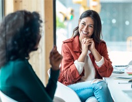 Woman smiling while talking to colleague at work 