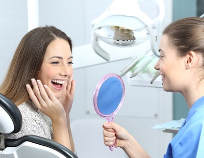 Woman admiring her new metal-free restorations in Aspen Hill