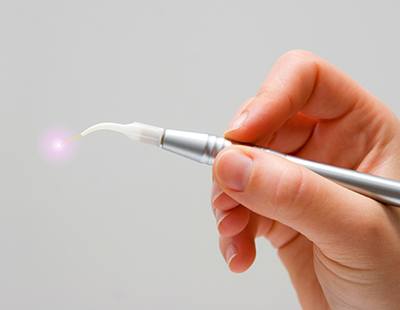 Hand holding a soft tissue dental laser