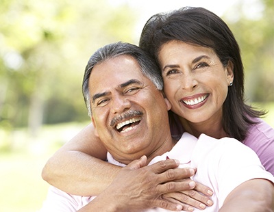 Man and woman smiling after dental crown restoration