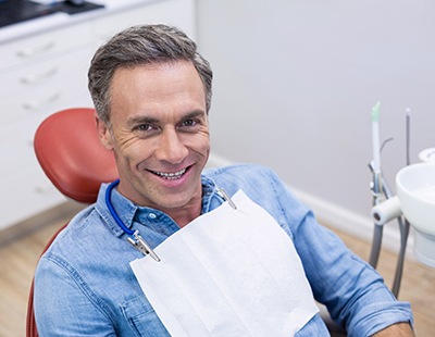 Male dental patient in denim jacket smiling