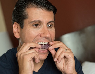 Man placing sleep apnea oral appliance