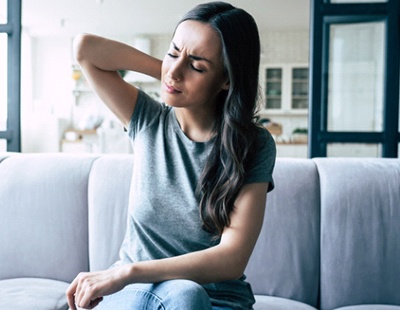 Woman with neckache, a symptom of TMJ disorder