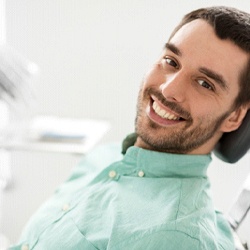 Man in green shirt at appointment for occlusal adjustment