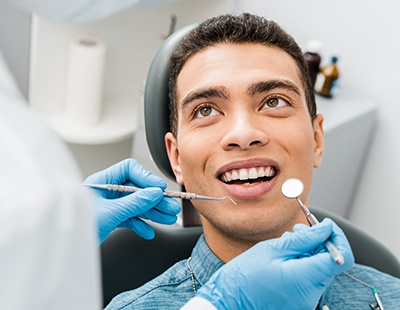 Young man smiling during checkup after wisdom tooth extraction