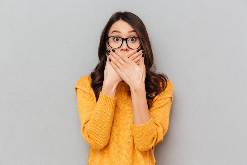 woman covering her smile