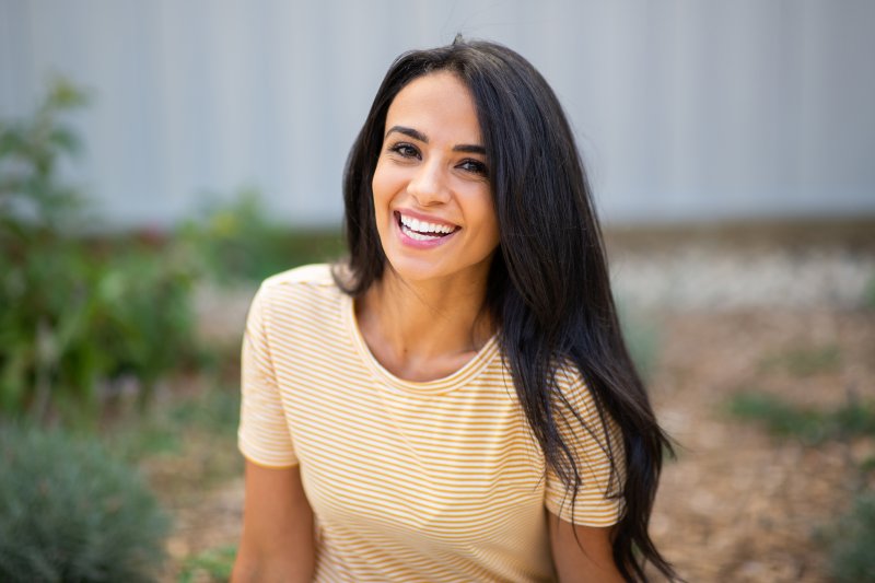 Woman smiles outside.