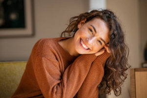 Smiling woman resting her head in her hands