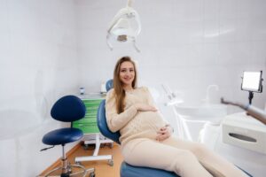 Smiling pregnant woman in dental treatment chair