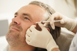 a smiling man receiving BOTOX